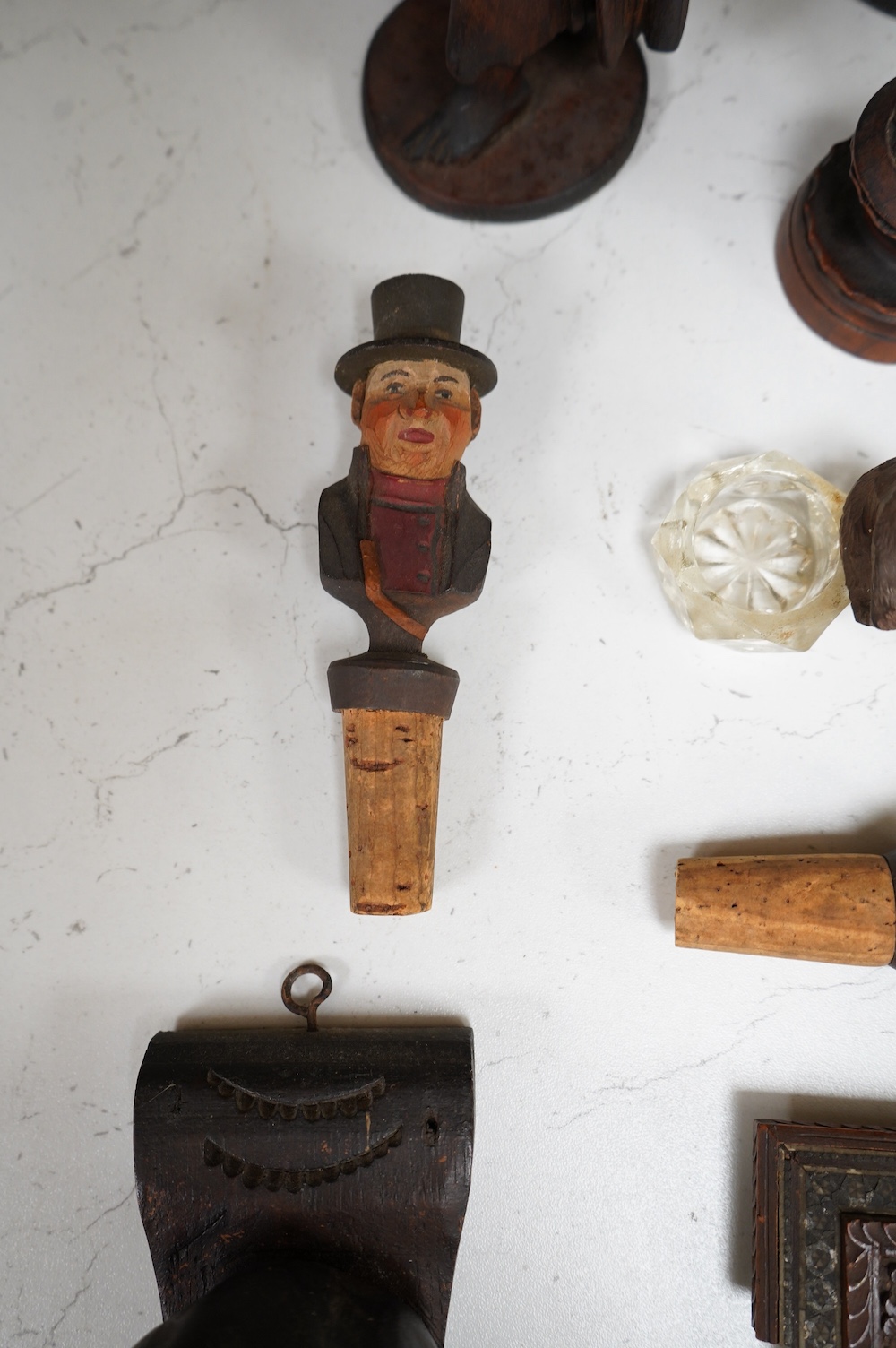 A collection of Black Forest wooden figurative carvings to include a pair of corbels in the form of musicians and a carved bear bottle stopper, largest 32cm high. Condition - mostly fair